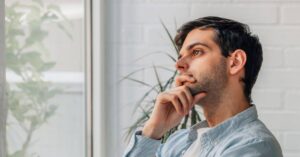 man thinking while looking out the window