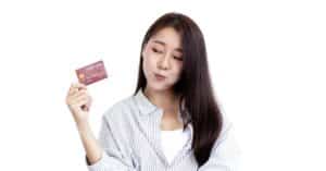 Woman looking mischievously at her credit card