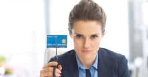 (woman holding a credit card with scissors)