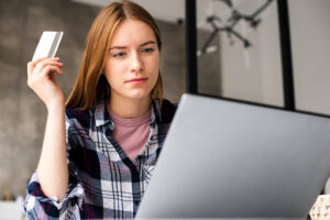 Person reviewing credit card expenses on a laptop